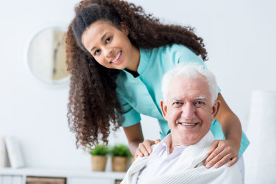woman caregiver and elderly man smiling